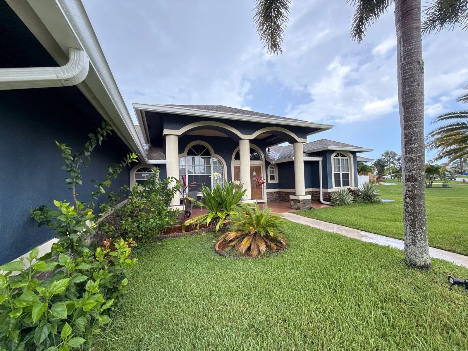 Navy blue stucco home with cream entry columns and trim in Port St. Lucie